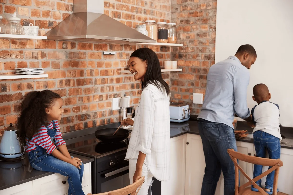 Eine Familie bereitet gemeinsam eine Mahlzeit zu, während Airis die Küche schützt