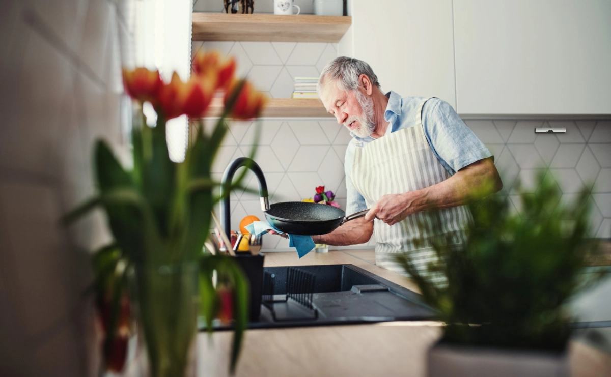 Oudere bewoner kookt veilig met Airis kookplaatbeveiliging